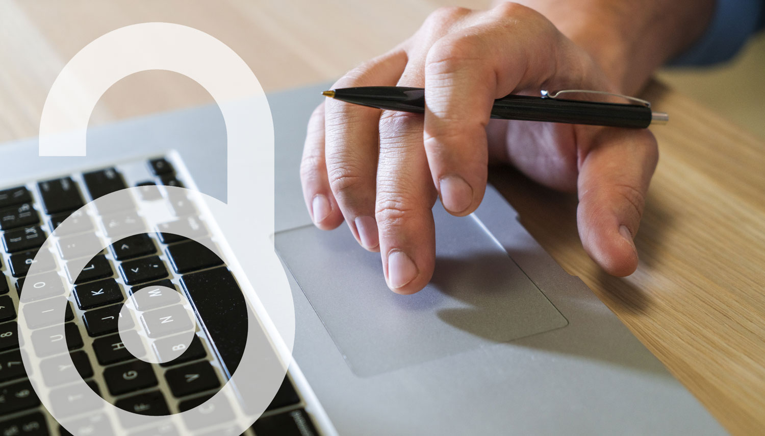 Hand mit Stift, die auf Laptop tippt